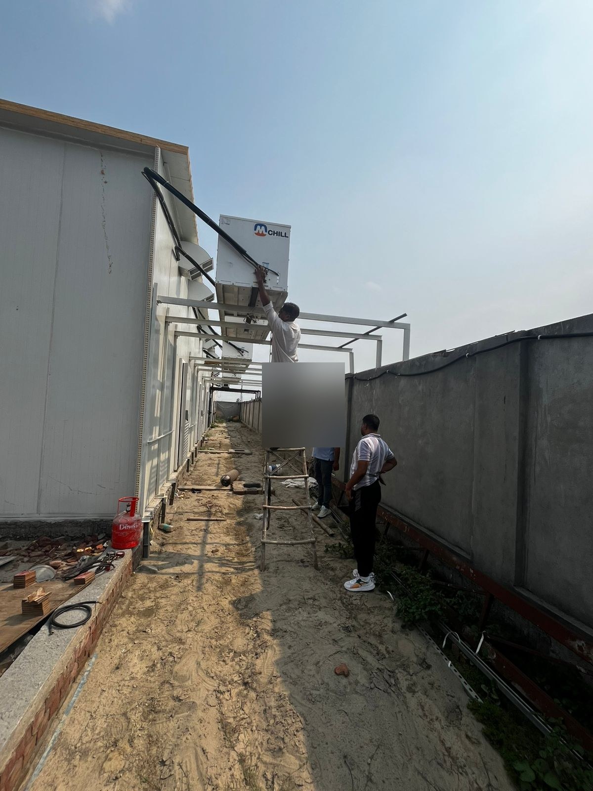 AC technician recharging R-404A refrigerant on mushroom farm grow room cooling unit